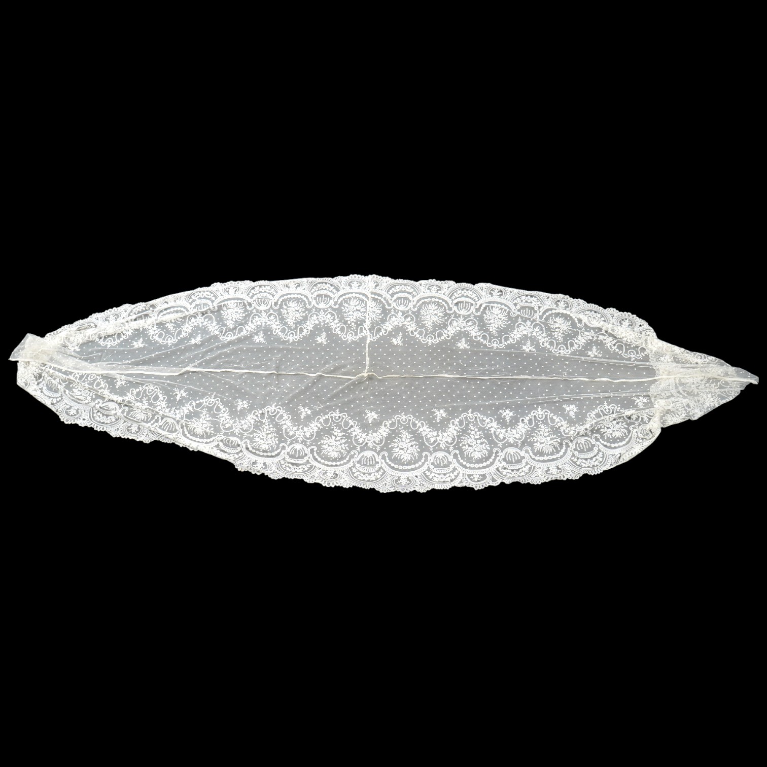 A wide flounce of fine ornate hand made 19th century Brussels bobbin lace, appliquéd onto a net ground, possibly commissioned for a wedding gown, now sewn together along the top edge and the two cut ends also stitched to